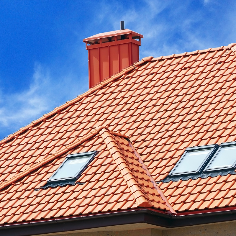 Isolation et Rénovation de Façade en Pleine Œuvre Rénovation de façade en cours : isolation thermique extérieure avec laine minérale et bardage en tôle ondulée rouge, échafaudage en place.